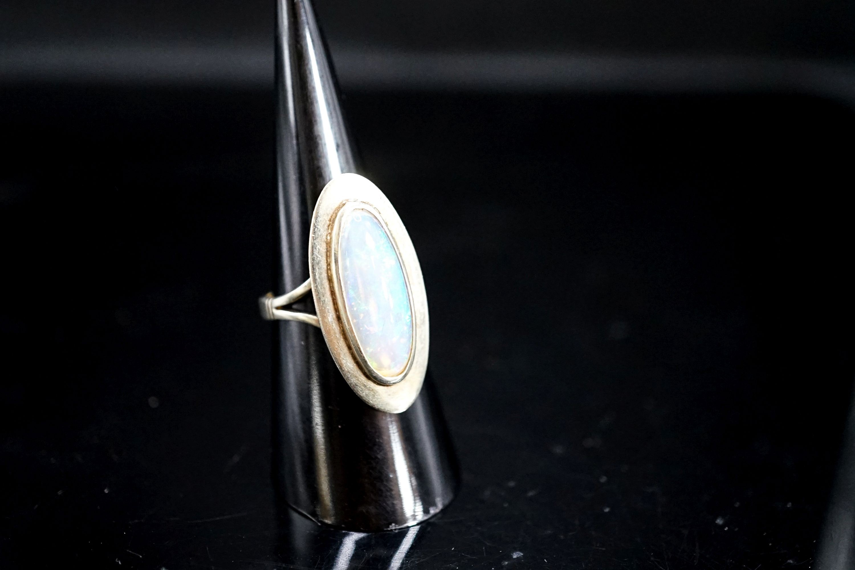 A 9ct and oval cabochon white opal set dress ring